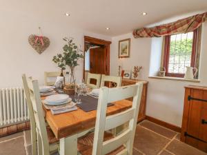 uma cozinha e sala de jantar com uma mesa de madeira e cadeiras em Hope Cottage em Bakewell