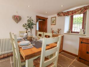 a kitchen and dining room with a wooden table and chairs at Hope Cottage in Bakewell