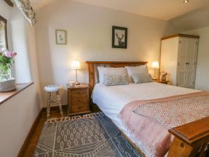 a bedroom with a bed and a table with two lamps at Hope Cottage in Bakewell