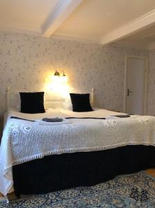 a bedroom with a large white bed with a light on it at Visingsö Pensionat in Visingsö