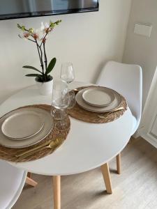 een witte tafel met borden en glazen erop bij Beach House Zandvoort in Zandvoort