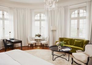 a living room with a green couch and a table at Hotel Diplomat Stockholm in Stockholm