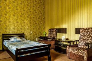 ザポリージャにあるHotel SEMのベッドルーム1室(ベッド1台、椅子2脚、テーブル付)
