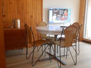 mesa y sillas en una habitación con TV en Appartement vue mer Port Vendres Collioure direct crique wifi, en Port-Vendres