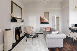 uma sala de estar com um sofá e uma mesa em The Portland Apartment - Georgian Building with parking em Bath