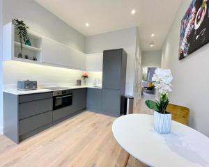 uma cozinha com uma mesa e um balcão branco em Chic, Newly Reno'd 1 Bed Open Plan, nr The Meadows em Edimburgo