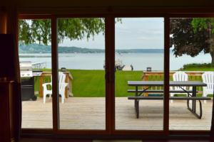 a view of a patio with a picnic table and a lake at The Summer House in Onekama