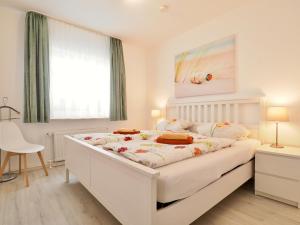 a bedroom with a large white bed with a window at Haus Gisela in Büsum