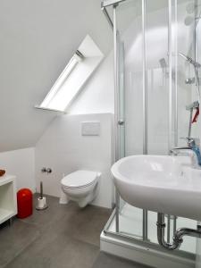 a white bathroom with a toilet and a sink at Haus Gisela in Büsum