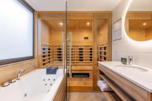 a bathroom with a tub and a sink and a shower at Center Parcs Meerdal Limburg-Brabant in America