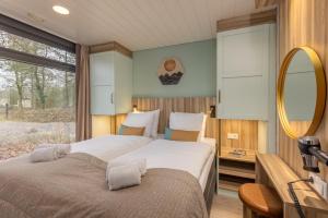 Center Parcs Meerdal Limburg-Brabant في أمريكا: غرفة نوم بسرير كبير ومرآة