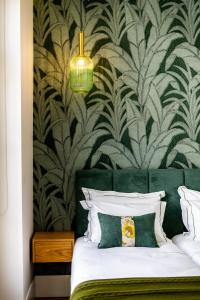 um quarto com uma cama com uma parede estampada verde e branca em Mouzinho 129 - Medronheiro & Oliveira no Porto