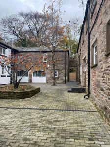 una calle adoquinada frente a un edificio de ladrillo en 4 Buttermere House, Cumbria with parking by Guestz, en Kirkby Thore