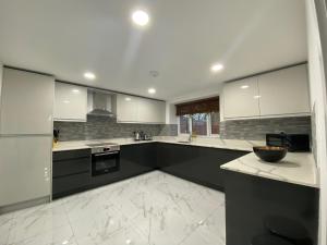 cocina grande con encimeras y electrodomésticos blancos en 4 Buttermere House, Cumbria with parking by Guestz, en Kirkby Thore