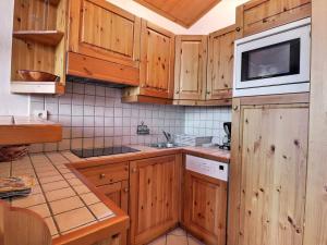 - une cuisine avec des placards en bois et un four micro-ondes dans l'établissement Appartement Méribel, 2 pièces, 4 personnes - FR-1-182-32, à Méribel