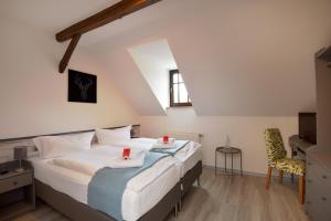 ein Schlafzimmer mit einem großen Bett und einem Stuhl in der Unterkunft Hotel Der Distelhof in Dillstädt