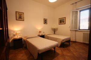 a room with two beds and a window at Azzurra ideale per famiglie in Donoratico