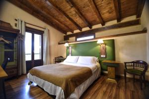1 dormitorio con 1 cama grande y pared verde en palacio de Orisoain, en Orísoain