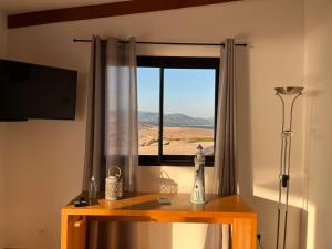 a room with a window and a table with a lamp at Residences La Tonnara in Bonifacio
