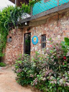 a stone building with a blue sign on it at Pousada da praça in Jericoacoara