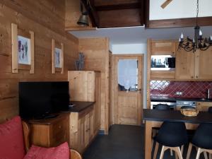 a kitchen with wooden walls and a counter with a table at Le Mazot - Avoriaz in Avoriaz