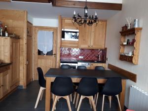 a dining room with a black table and chairs at Le Mazot - Avoriaz- séjours du dimanche au dimanche in Avoriaz