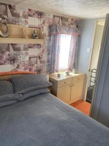 a bedroom with a bed and a window at L&g FAMILY HOLIDAYS 8 BERTH SEALANDS FAMILYS ONLY AND THE LEAD PERSON MUST BE OVER 30 in Ingoldmells