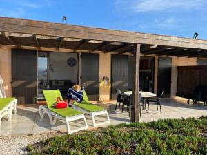 a patio with green chairs and a table on a patio at Residences La Tonnara in Bonifacio