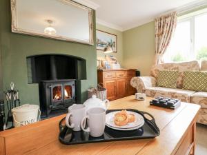 a living room with a table with a tray of food at Aditum Cottage in Market Rasen