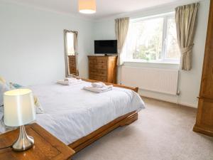 Un pat sau paturi într-o cameră la Aditum Cottage