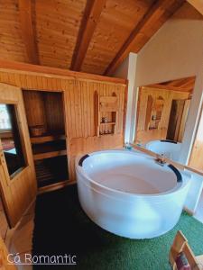 eine große weiße Badewanne in einem Zimmer mit Holzdecken in der Unterkunft Romantic Spa in Venas