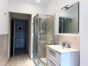 uma casa de banho com uma cabina de duche em vidro e um lavatório. em The Lighthouse - Central Apartment Aosta - cir 0234 em Aosta