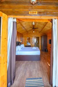 a bedroom with a large bed in a wooden room at Summer Sky Beach Resort in Agonda