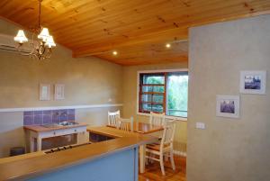 a kitchen with a wooden ceiling and a table and chairs at Barrington Hideaway- River Cottages in Gloucester