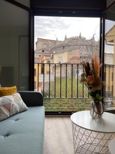 uma sala de estar com um sofá e uma grande janela em Estrada Suites em Ávila