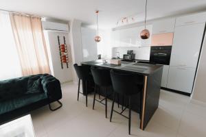 a kitchen with a black island with black chairs at Bear's Apartment Alba Iulia in Alba Iulia