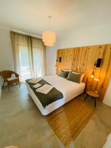 - une chambre avec un grand lit et un mur en bois dans l'établissement Villa Sal - Alvor, à Alvor