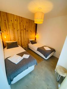 two beds in a room with wooden walls at Villa Sal - Alvor in Alvor