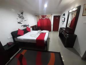 a bedroom with a bed and a dresser and a mirror at kurinji residency in Ooty