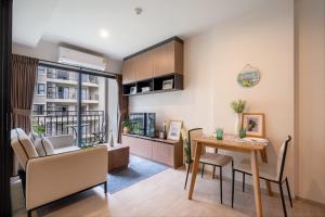 Un comedor y una sala de estar con mesa y sillas. en Lacasita Near Beach Huahin (Room564), en Hua Hin