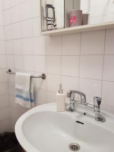 biała łazienka z umywalką i ręcznikiem w obiekcie Villa Barbara w mieście Mlini