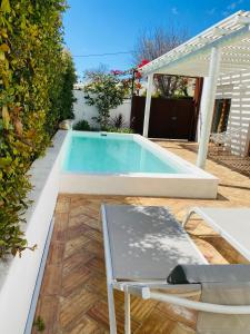 a swimming pool in a backyard with a table and a chair at Villa Sal - Alvor in Alvor