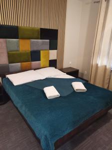 a bedroom with a bed with two towels on it at Uslugi hotelowe A1 in Łódź