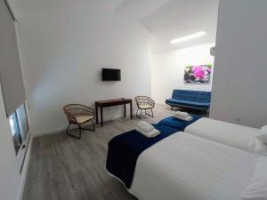 1 dormitorio con cama, mesa y sofá en Tanoeiros Studios, en Funchal