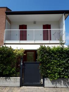 Casa blanca con puerta azul y balcón en Casa Christian & Marisa (con piscina), en Cavallino-Treporti