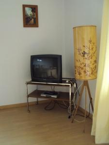 einen TV und einen Tisch mit einer Lampe in einem Zimmer in der Unterkunft Haus Werrablick in Hannoversch Münden