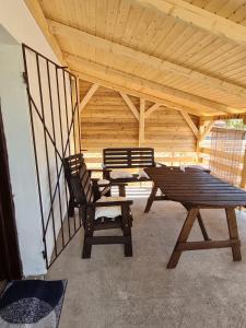 zwei Bänke und ein Picknicktisch in einem Pavillon in der Unterkunft Kakasdombi Apartman in Balatonszabadi