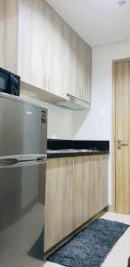 馬尼拉的住宿－S Residences-MOA，厨房配有木制橱柜和炉灶。