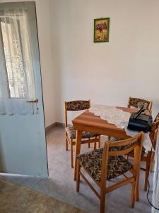comedor con mesa, sillas y puerta en Kakasdombi Apartman en Balatonszabadi