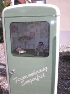 einem grünen Gasspender mit einem Tisch und einem Regenschirm in der Unterkunft Ferienwohnung Sorgenfrei in Bad Krozingen